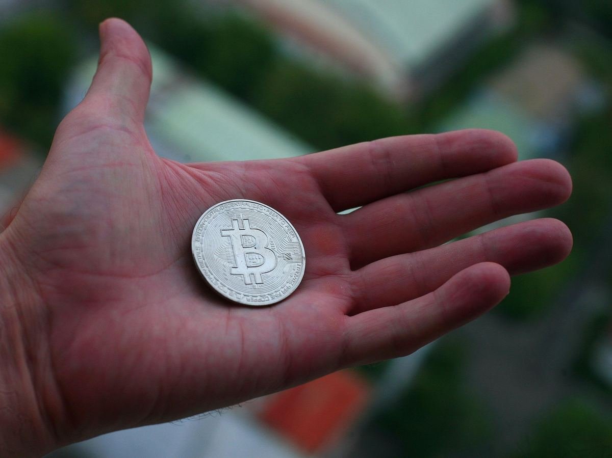 Una mano sosteniendo una sola moneda: empezar a invertir con poco